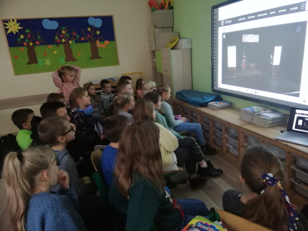 Uczniowie oglądają przedstawienie internetowe.