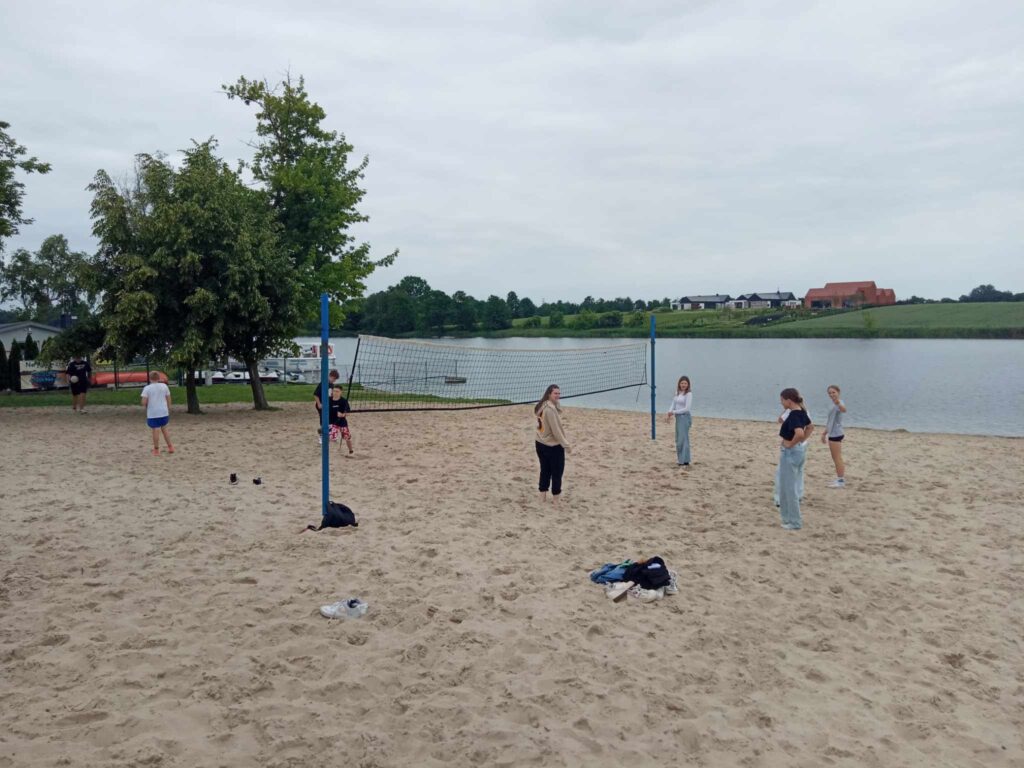 Uczniowie grają w siatkówkę na plaży