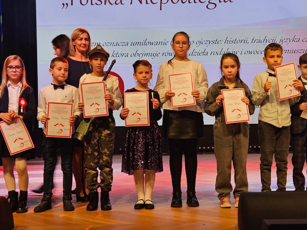 Uczniowie stoją z dyplomami